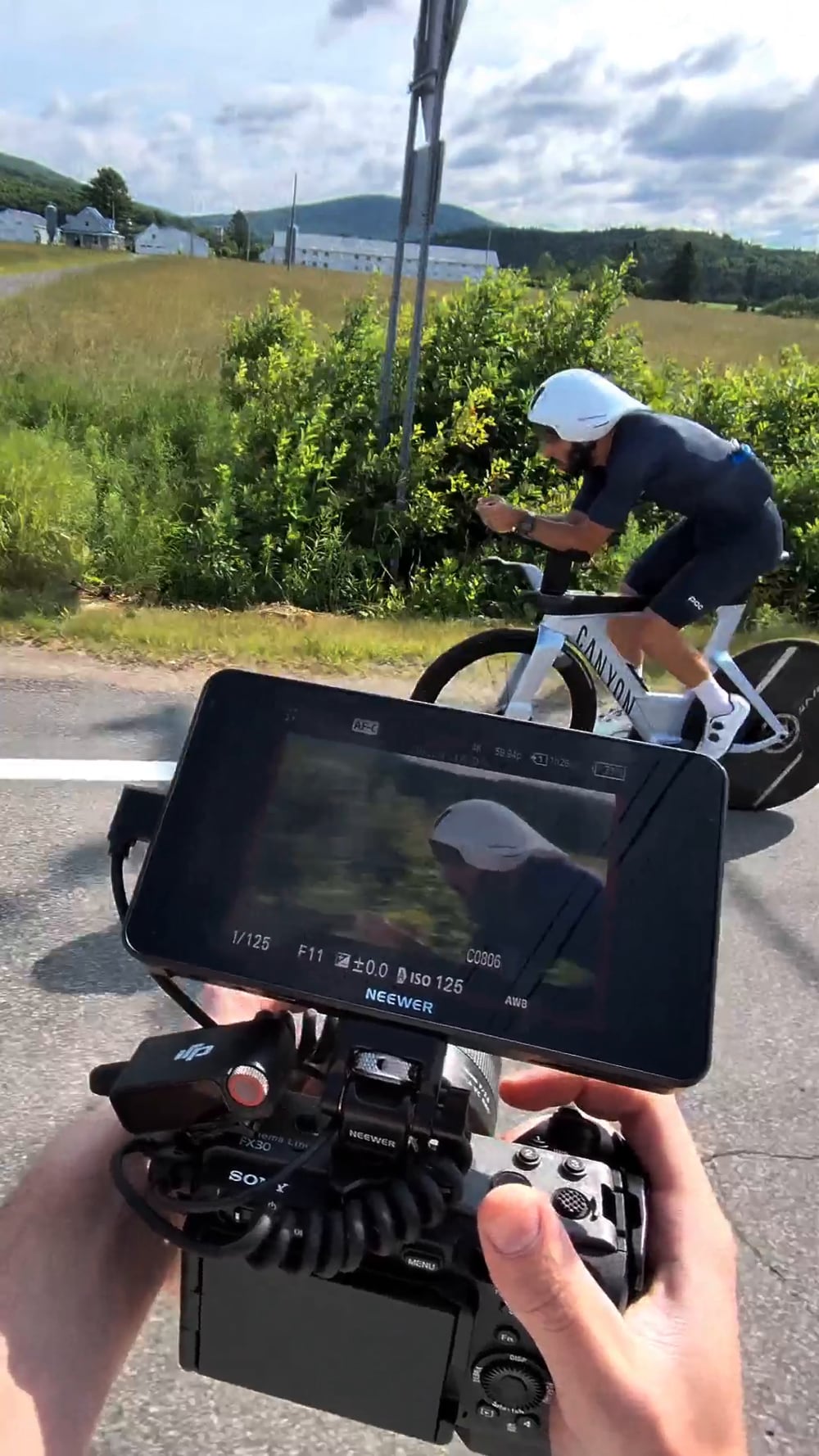 Équipe filmant un cycliste sur la route